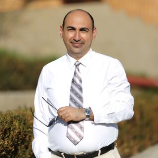 Aram Simonyan smiles. He has a white shirt and tie.